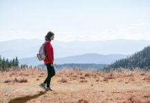 일과 건강, 균형 잡기…직장인을 위한 ‘마이크로 웰니스’ 실천법 a man with a backpack walking across a dry grass covered field