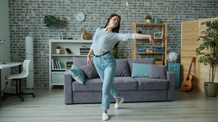 Young woman dancing in a modern living room.