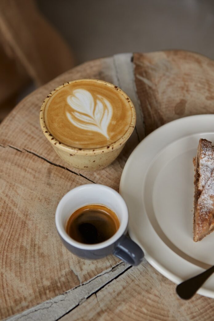 A plate with a piece of pie on it next to a cup of coffee