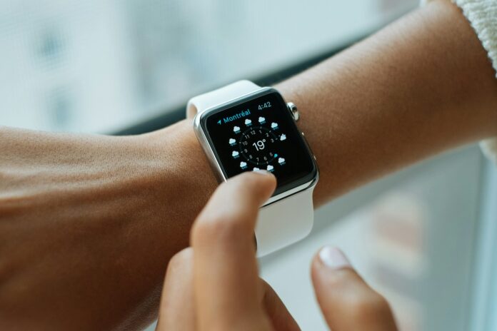 Photo by Luke Chesser person wearing silver aluminium case Apple Watch with white Sports Band