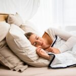 “깊은 잠을 부르는 수면 최적화 비법: 언제 어디서든 실천하는 방법” a woman sleeping in a bed with a white comforter